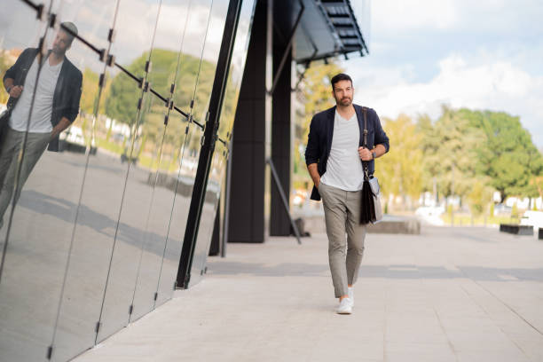Men's Summer Outfit Ideas: Stay Cool & Stylish modern young caucasian businessman walking on his way to work.